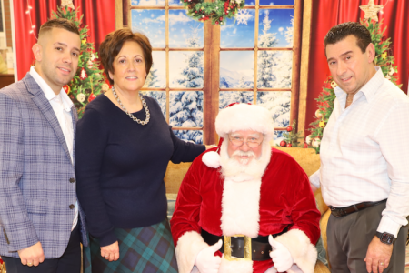 Foto: JORNAL LUSO-AMERICANO | O casal Guerra e o filho, Shawn Guerra, com o Pai Natal na loja da Ferguson Street